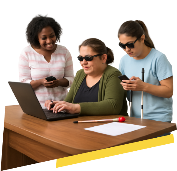 Fotograf&iacute;a de tres mujeres no videntes colaborando en un espacio de trabajo. La mujer en el centro, con gafas oscuras, est&aacute; escribiendo en un computador port&aacute;til sobre una mesa de madera, con un bast&oacute;n blanco a su lado. A su izquierda, una mujer joven, tambi&eacute;n con gafas oscuras, est&aacute; manipulando su tel&eacute;fono m&oacute;vil mientras sostiene su bast&oacute;n blanco. A la derecha, una mujer de piel oscura, con gafas oscuras, sonr&iacute;e mientras sostiene su tel&eacute;fono.